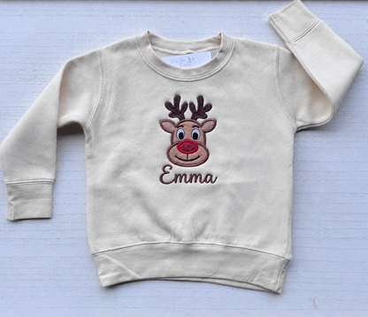 Personalized toddler reindeer sweatshirt in Nature with the name Emma embroidered beneath the design in brown thread.