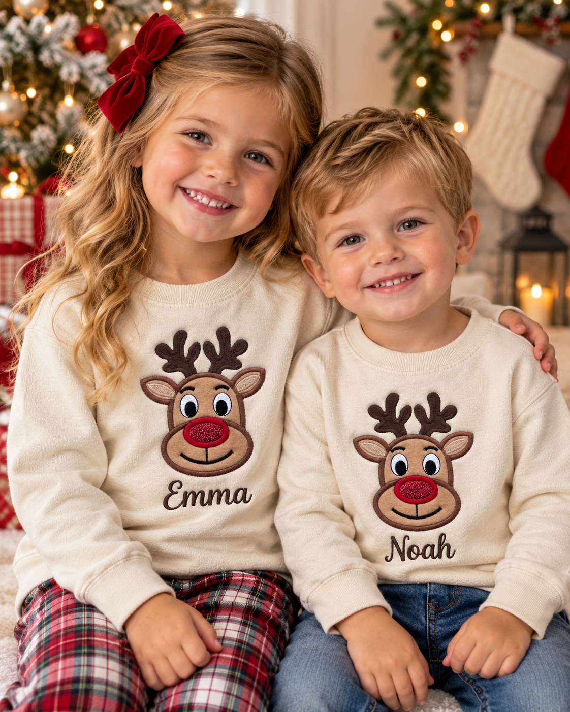 Two young siblings wearing matching personalized Christmas reindeer sweatshirts with embroidered names Emma and Noah.