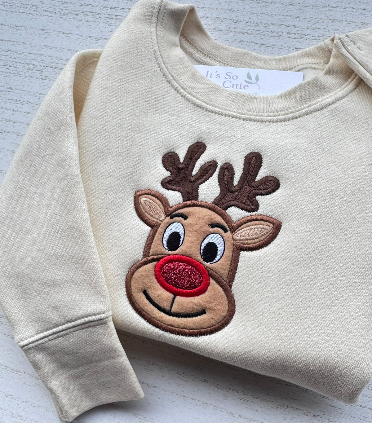 Nature toddler Christmas sweatshirt featuring a handmade embroidered reindeer appliqué with a sparkling red nose.