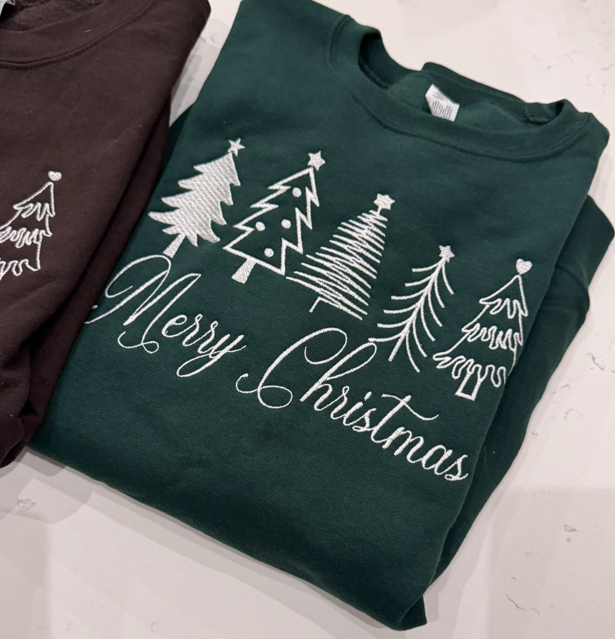 Forest green Merry Christmas sweatshirt with four white embroidered Christmas trees