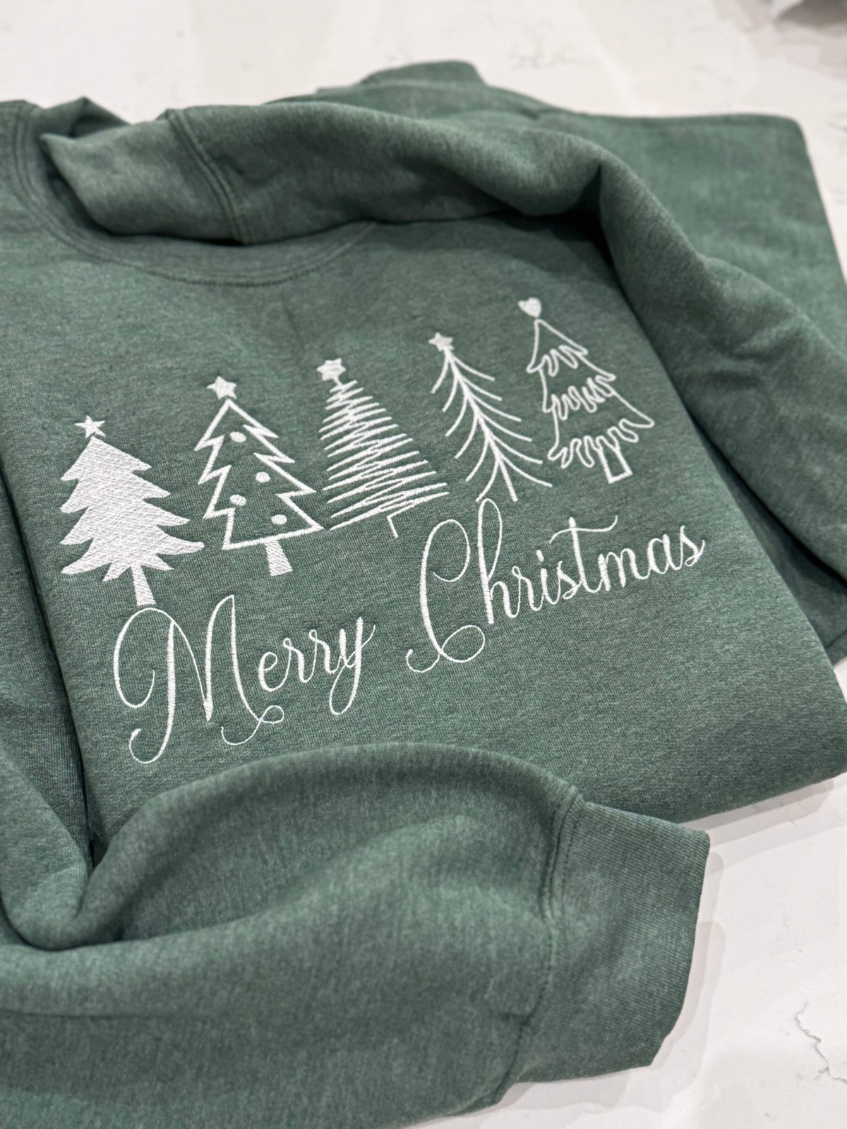 Close-up of white thread Christmas tree embroidery on holiday sweatshirt