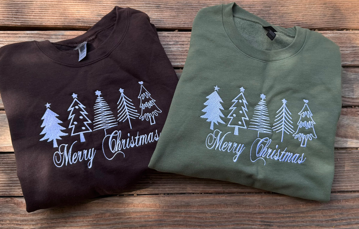 two Classic embroidered Christmas sweatshirts with white trees and Merry Christmas script