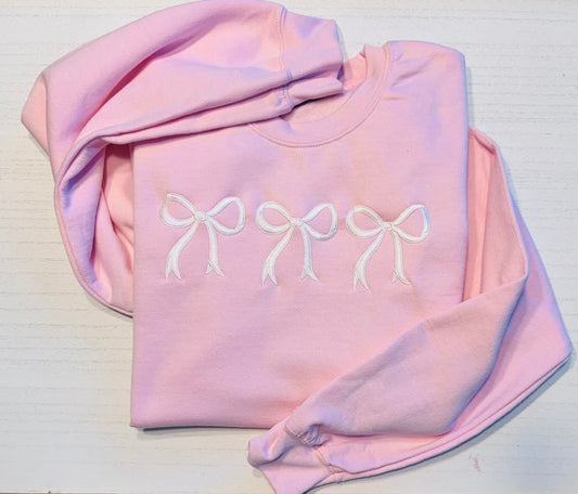 Pink sweatshirt with three white embroidered coquette bows and personalized sleeve cuff