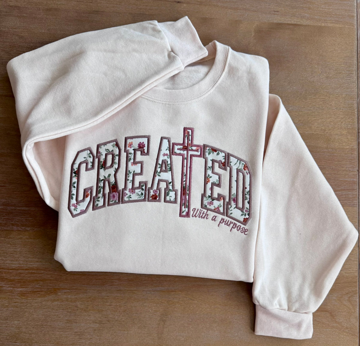Close-up of With a Purpose embroidered on the sweatshirt sleeve