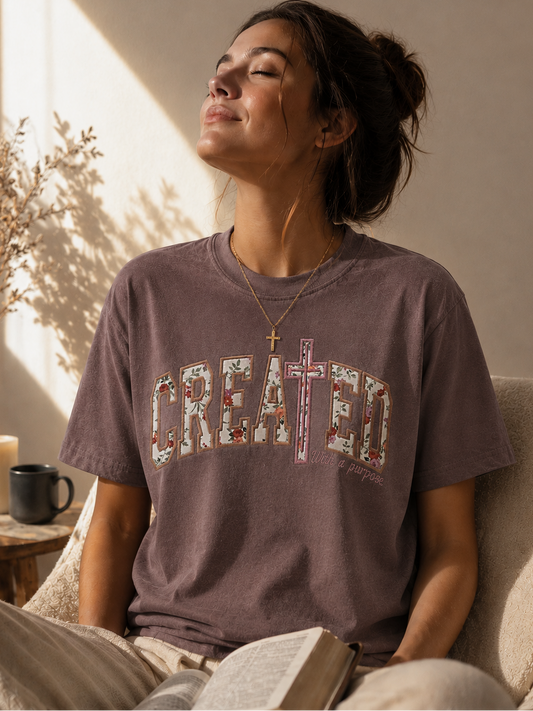 Woman wearing a Comfort Colors Christian shirt with Created With a Purpose floral appliqué