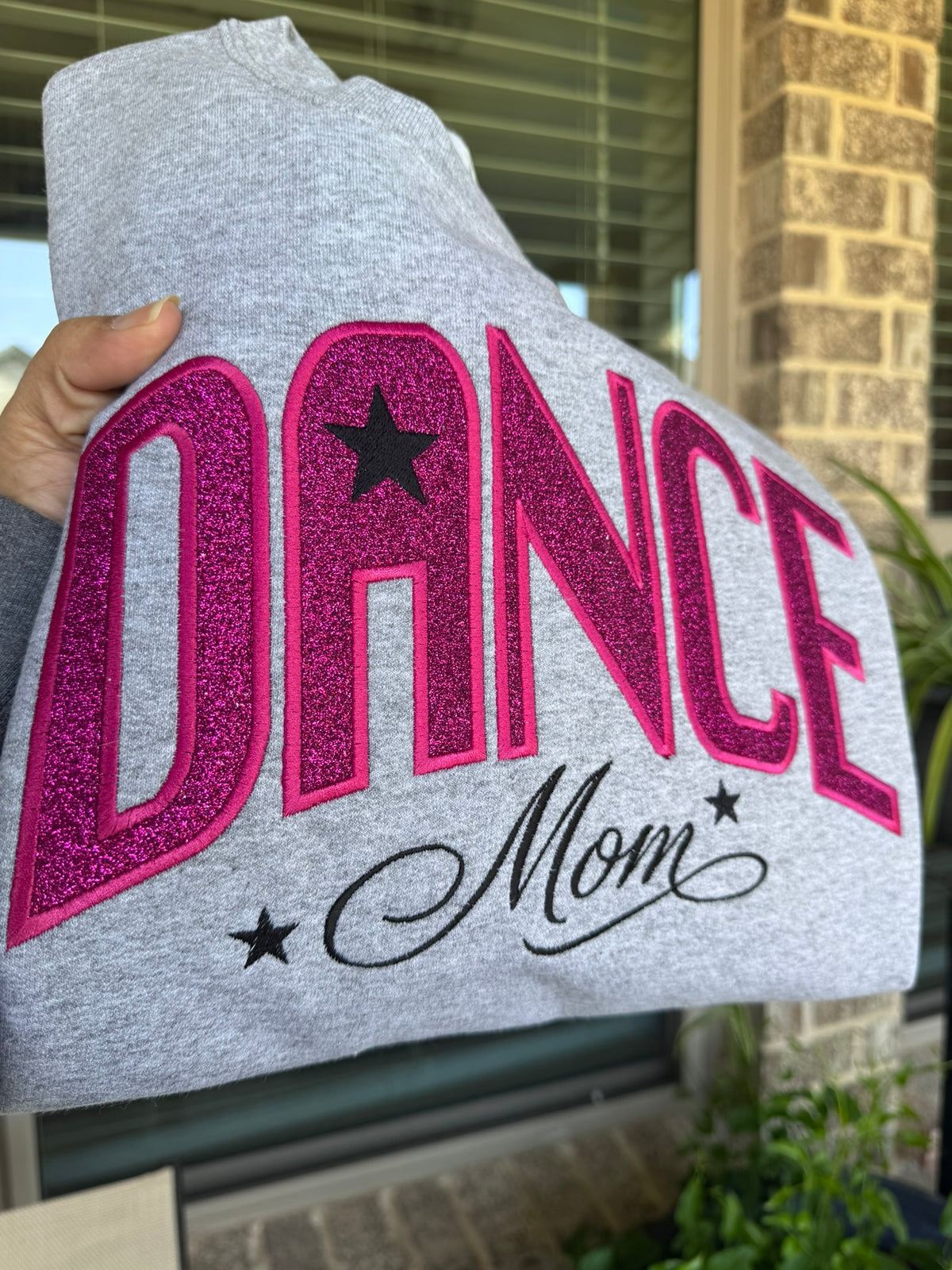 Personalized Dance Mom sweatshirt displayed outdoors with hot pink sparkle lettering