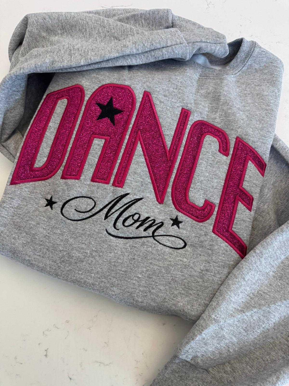 Folded Dance Mom sweatshirt featuring pink sparkle appliqué and embroidery