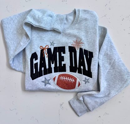 Folded ash Game Day sweatshirt with black lettering and orange glitter football