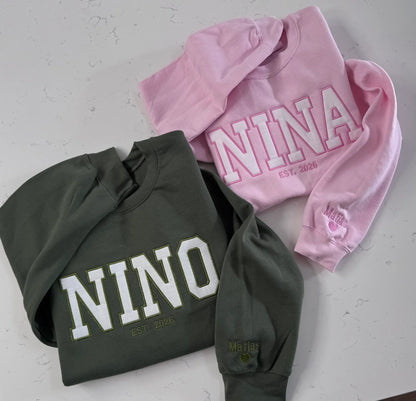 Close-up of custom name embroidery on sleeve of Mama varsity sweatshirt