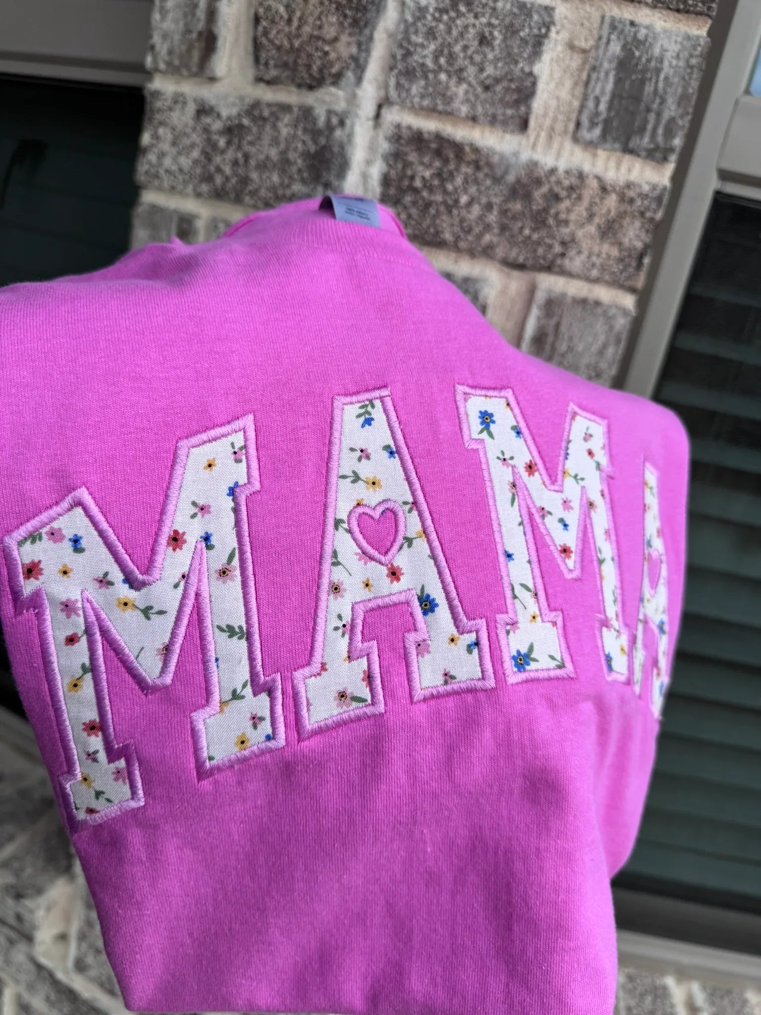 Close-up of floral embroidery and custom name on personalized Mama shirt