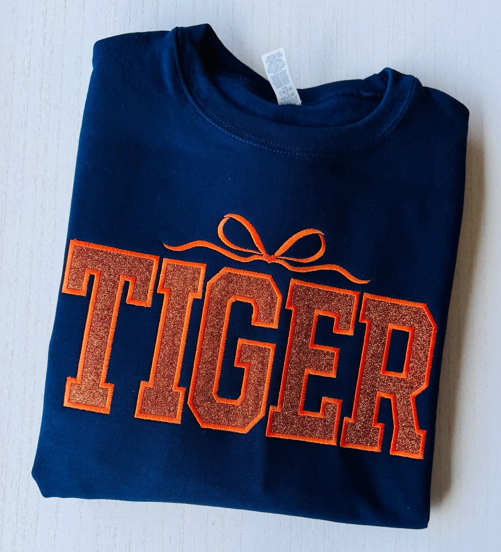 Close-up of college style varsity lettering on tiger glitter sweatshirt