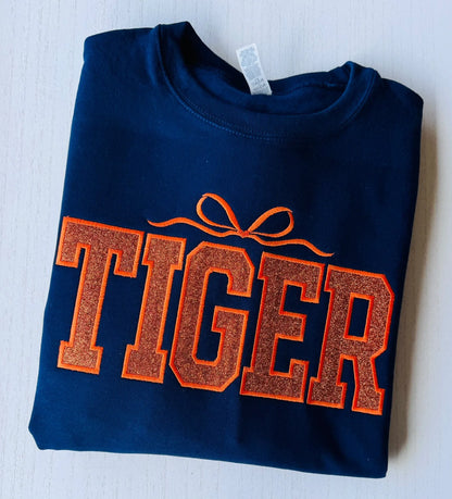 Close-up of college style varsity lettering on tiger glitter sweatshirt