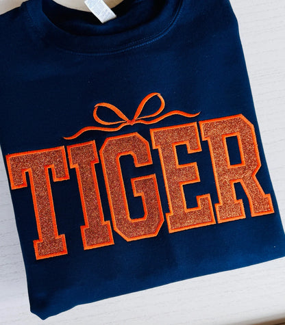 Close-up of tiger embroidery with glitter detail on varsity sweatshirt