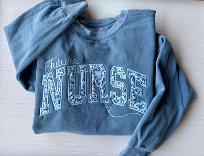 Future Nurse embroidered sweatshirt styled on wooden background
