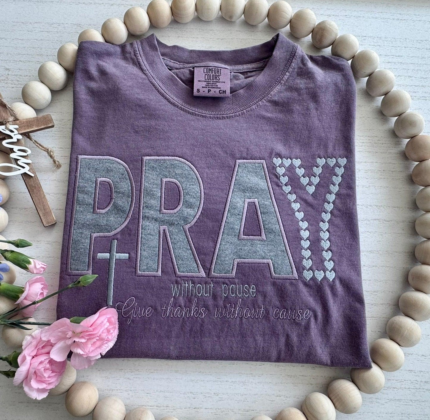 PRAY appliqué embroidery close up heather gray textured fabric cross detail