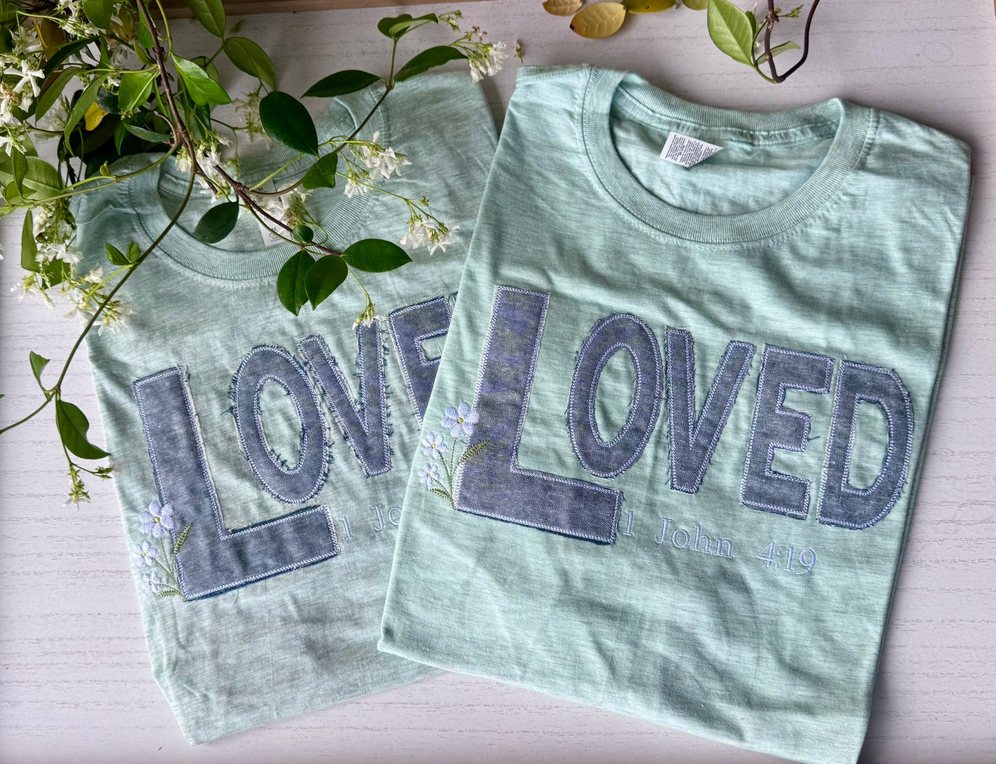 Close-up of LOVED denim appliqué embroidery with intentionally frayed edges