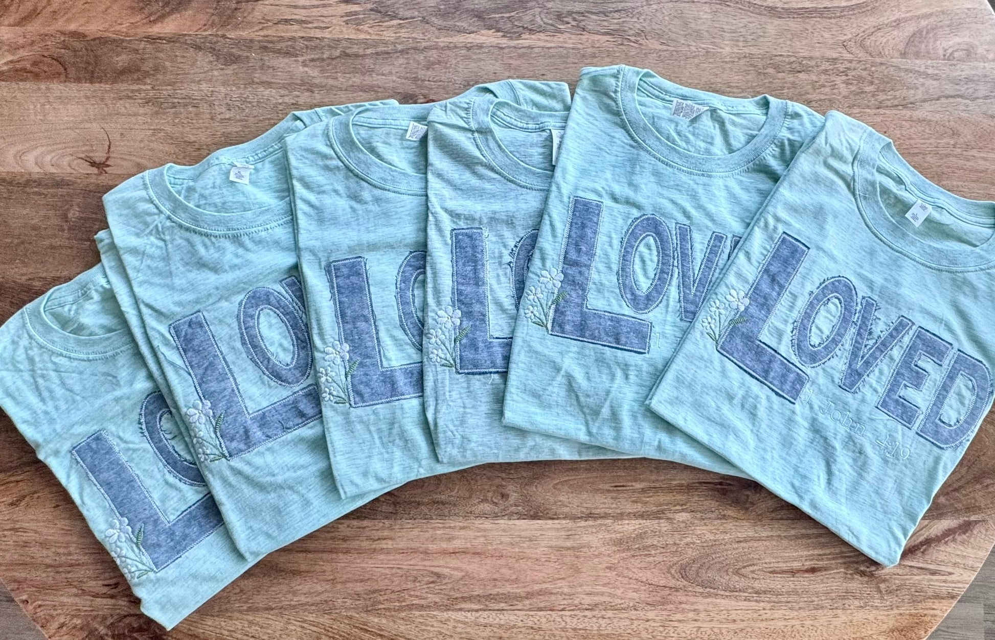 LOVED tee with 1 John 4:19 scripture embroidery and floral details