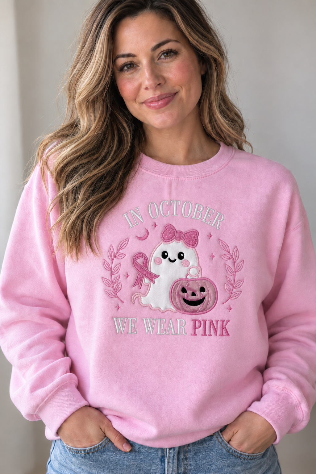 Woman wearing a pink In October We Wear Pink embroidered sweatshirt