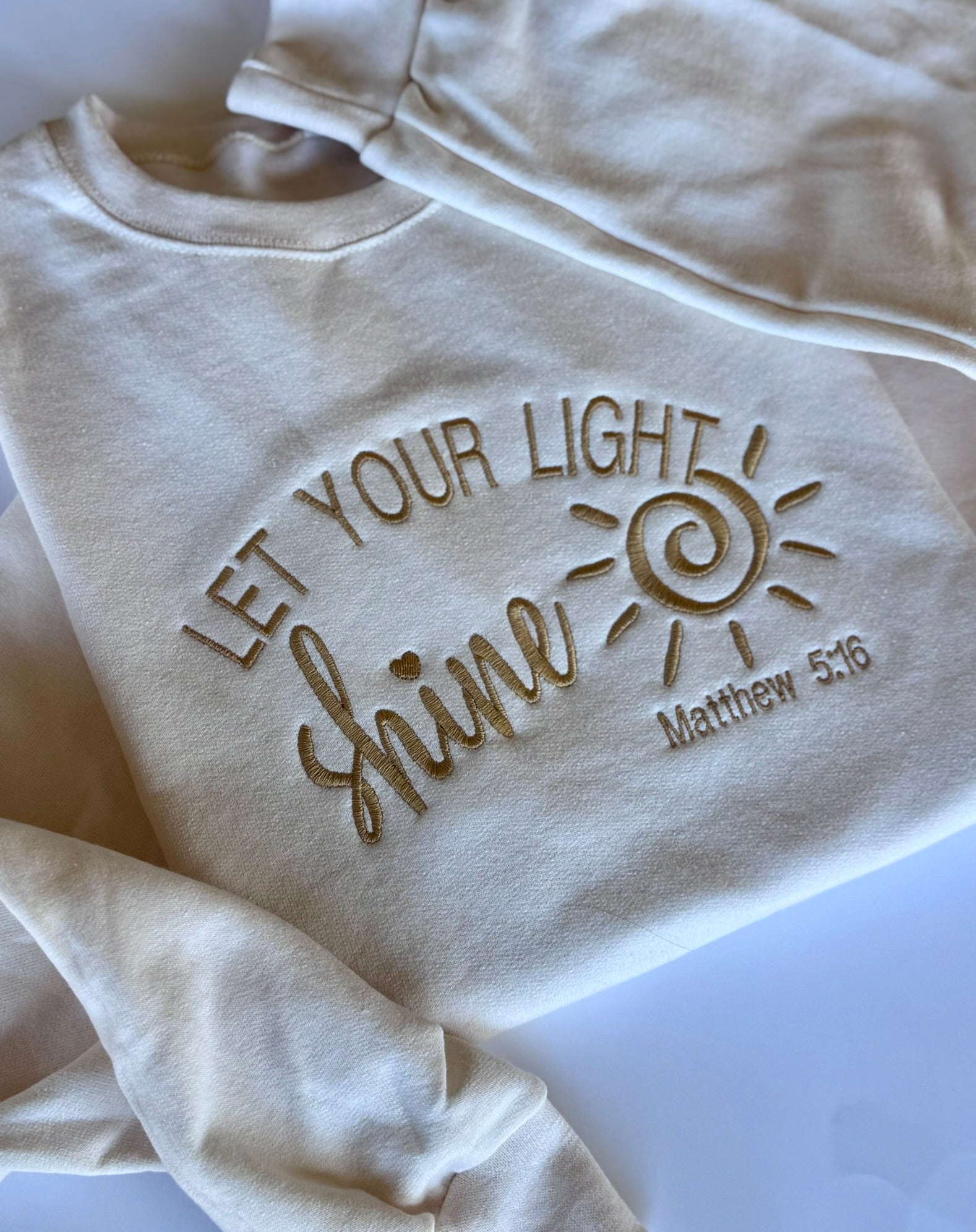 Close-up of Matthew 5:16 Bible verse embroidery on Let Your Light Shine sweatshirt