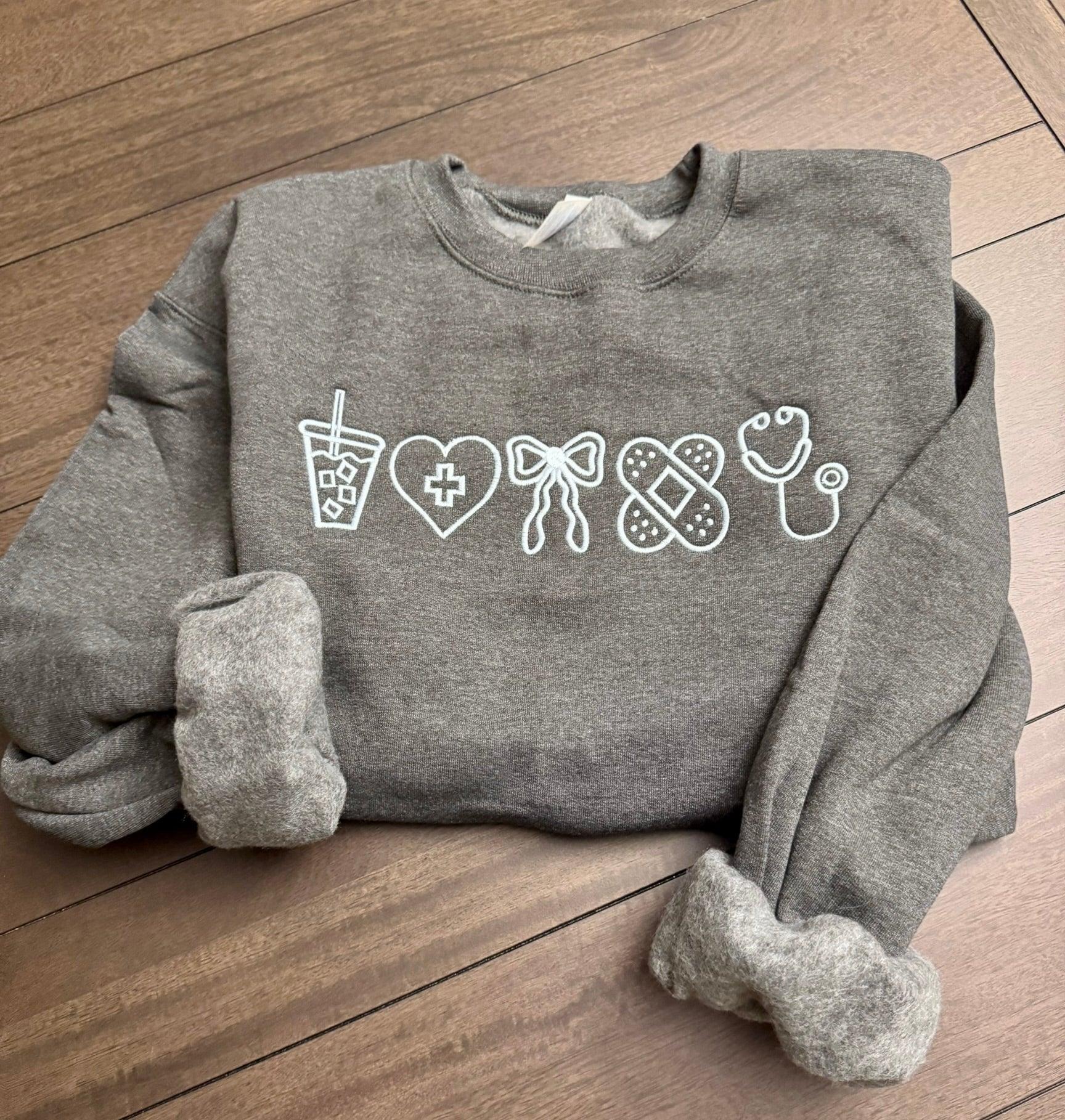 Gray sweatshirt with white graphic designs about accessories for nurse