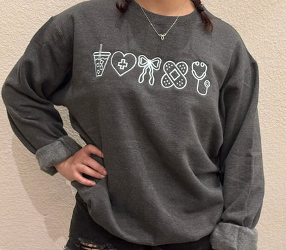 Person wearing a dark gray sweatshirt with white graphic designs about accessories  of nurse