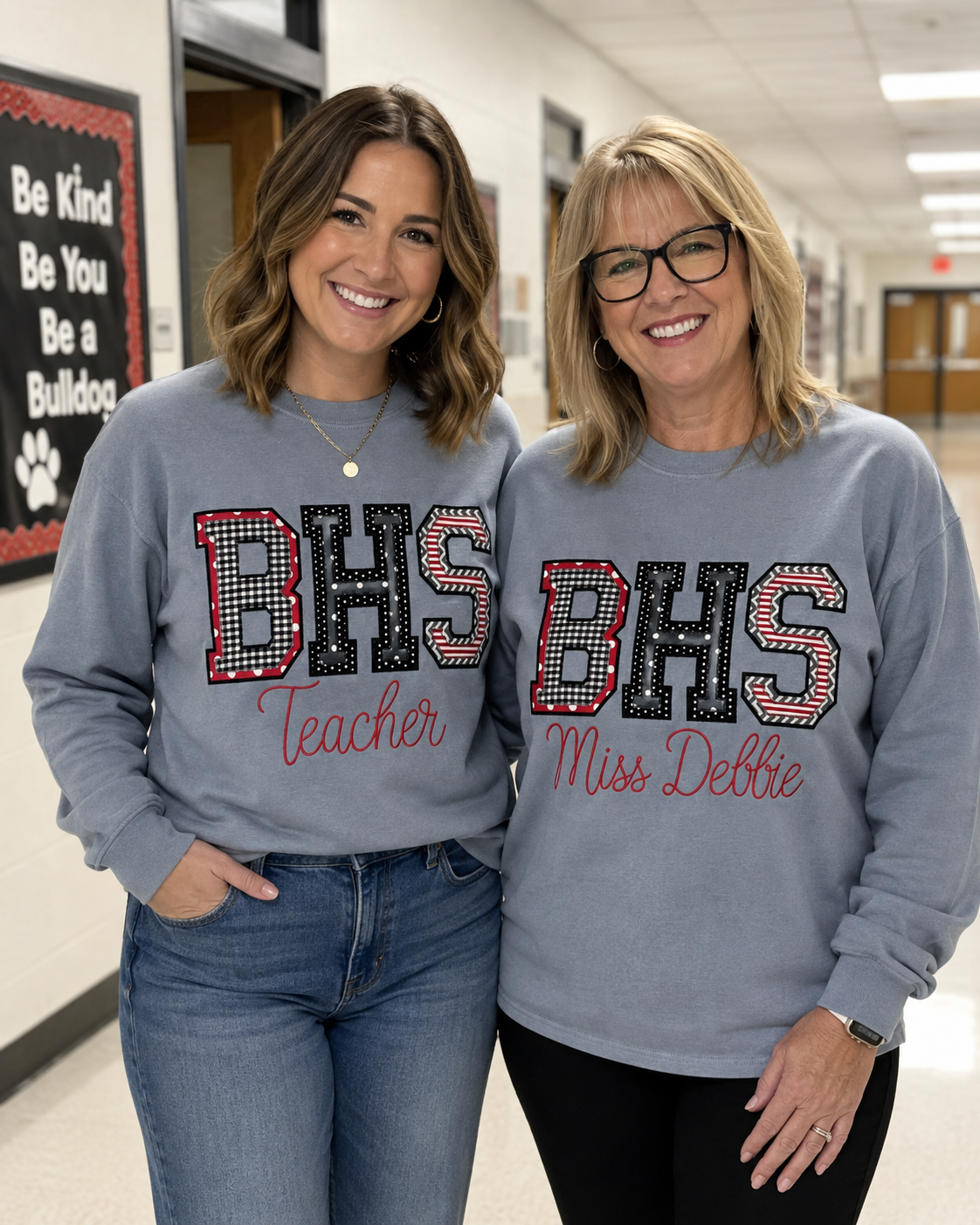 Two teachers wearing personalized BHS school spirit shirts with Teacher and Miss Debbie embroidered below the applique initials.