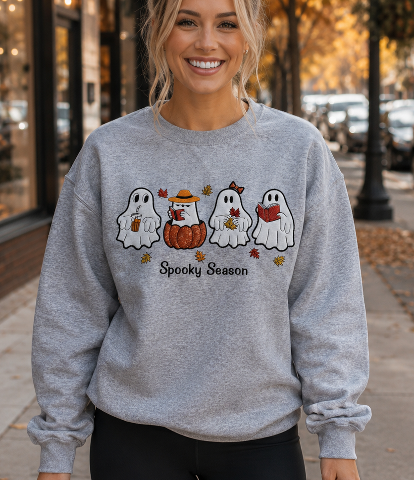 Lifestyle view of woman wearing a gray embroidered Halloween ghost sweatshirt