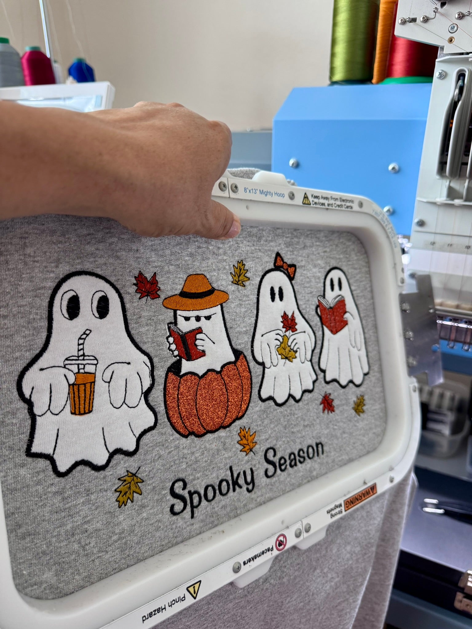 Close-up of detailed ghost embroidery on a Spooky Season sweatshirt