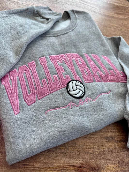 Gray sweatshirt with pink 'Volleyball' text and volleyball icon on a wooden surface