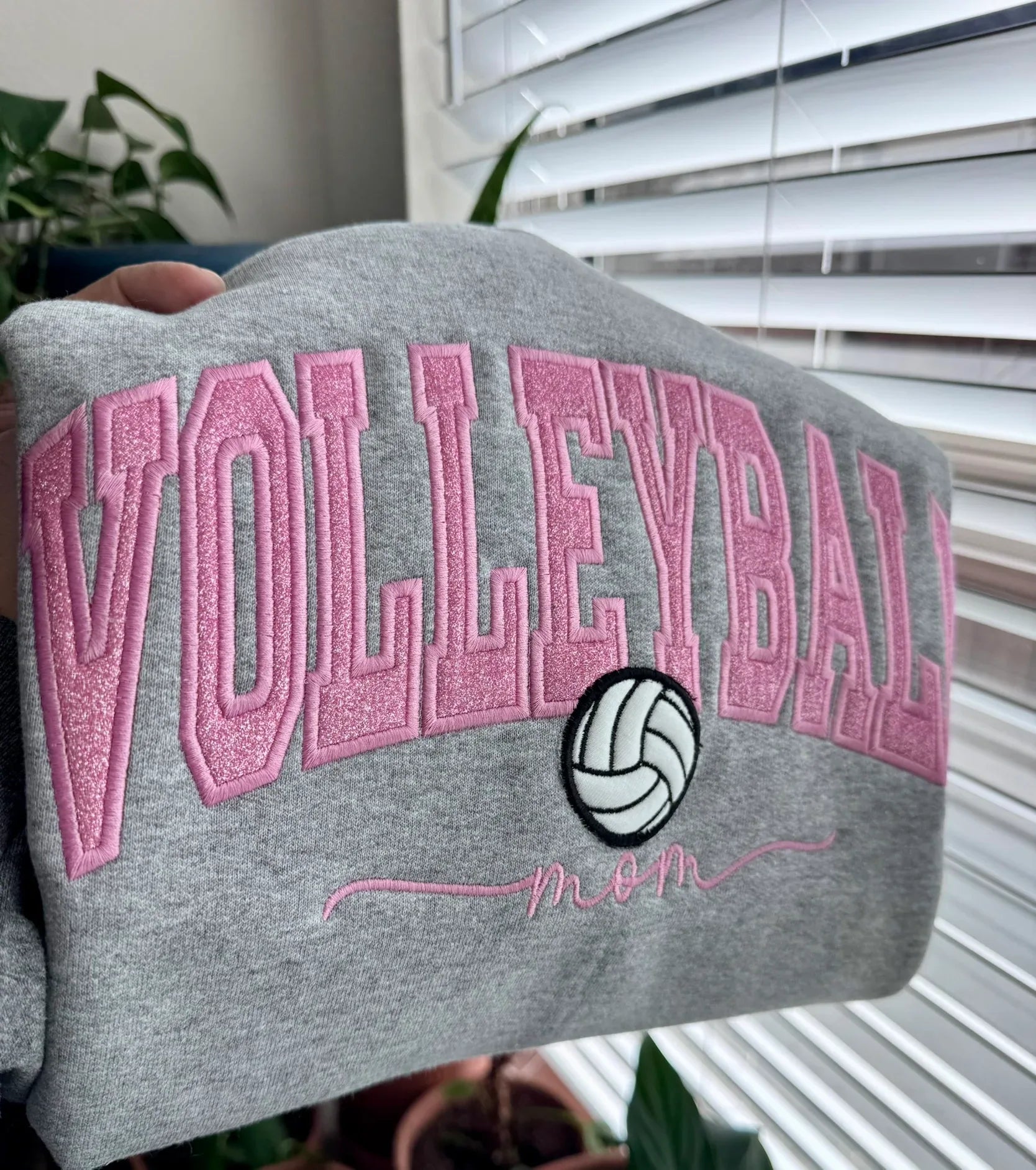 Gray sweatshirt with pink 'VOLLEYBALL mom' text and volleyball design, personalized with name