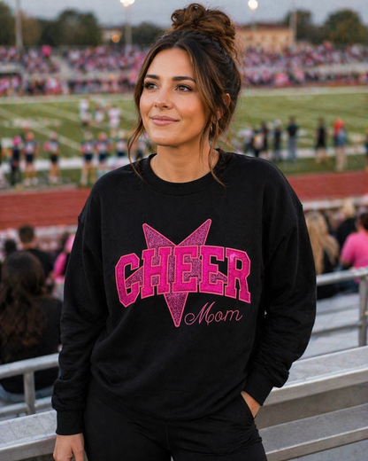 Woman wearing a personalized black Cheer sweatshirt with pink sparkle appliqué