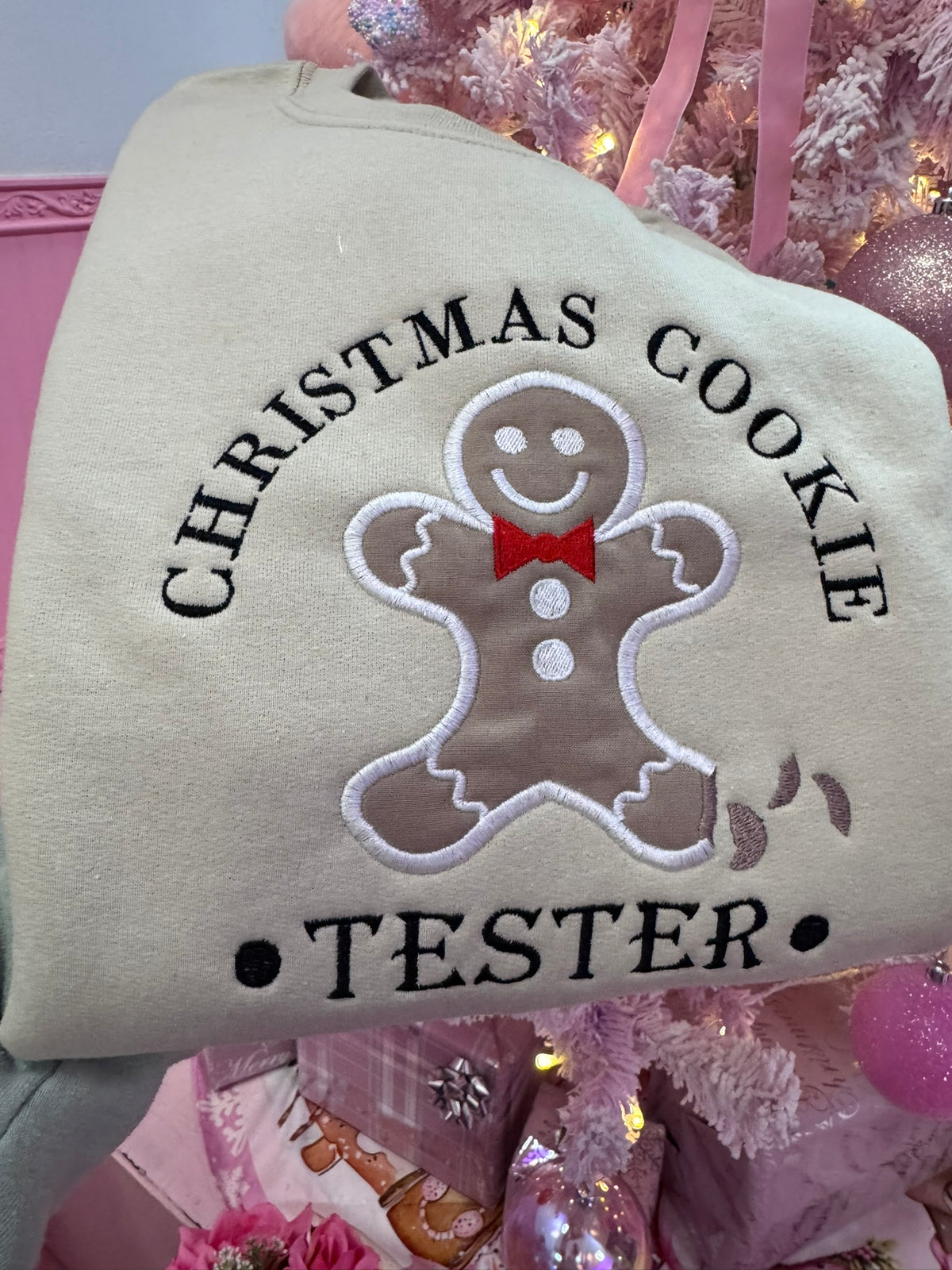 Close-up of gingerbread cookie appliqué and Christmas Cookie Tester embroidery on neutral sweatshirt