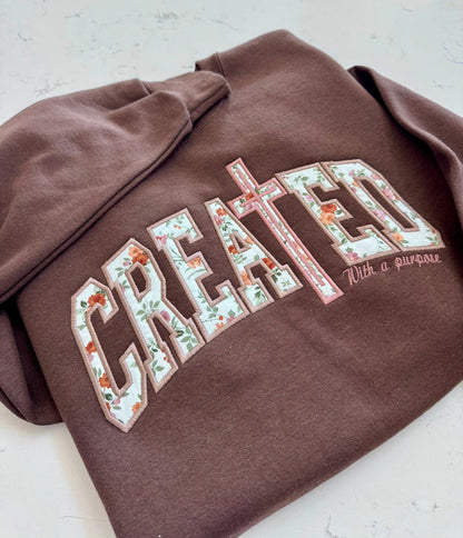 Chocolate Created With a Purpose sweatshirt with floral fabric appliqué and cross detail